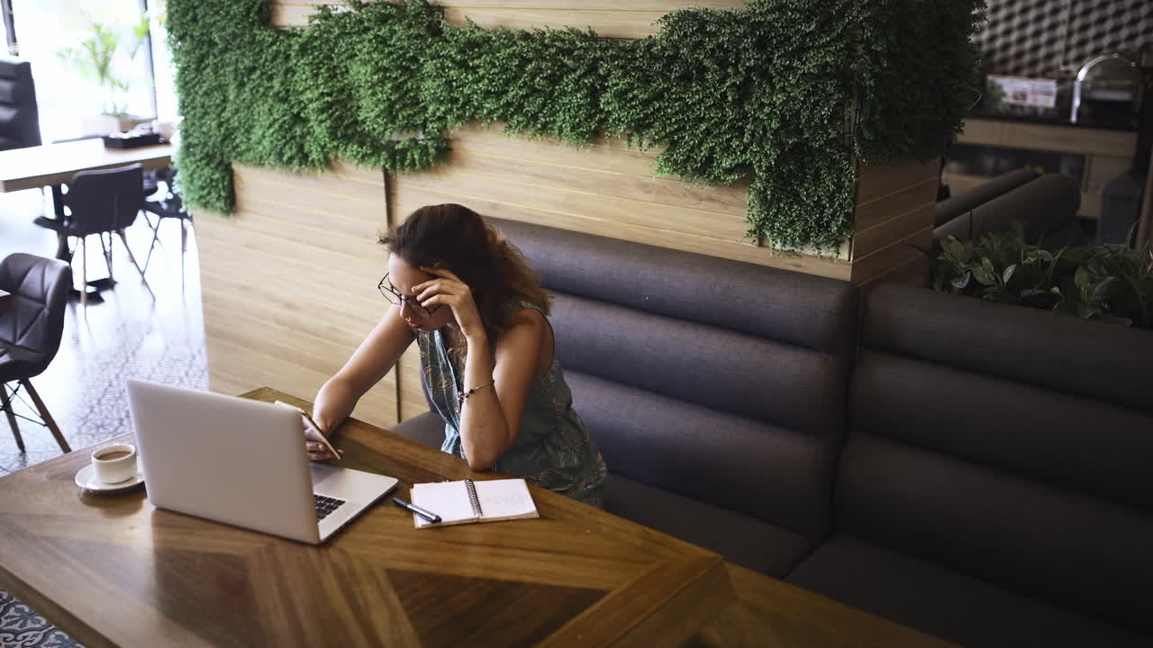 a young woman looking stressed using a laptop