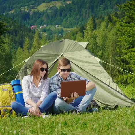Young-People-Are-Resting-In-The-Campsite-And-They-Use-Laptops-1