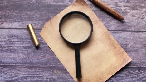 Open book and magnifying glass on table