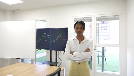 Black-African-business-woman-looking-at-camera-with-a-trading-view-graphic-in-the-background-serious-face-expression