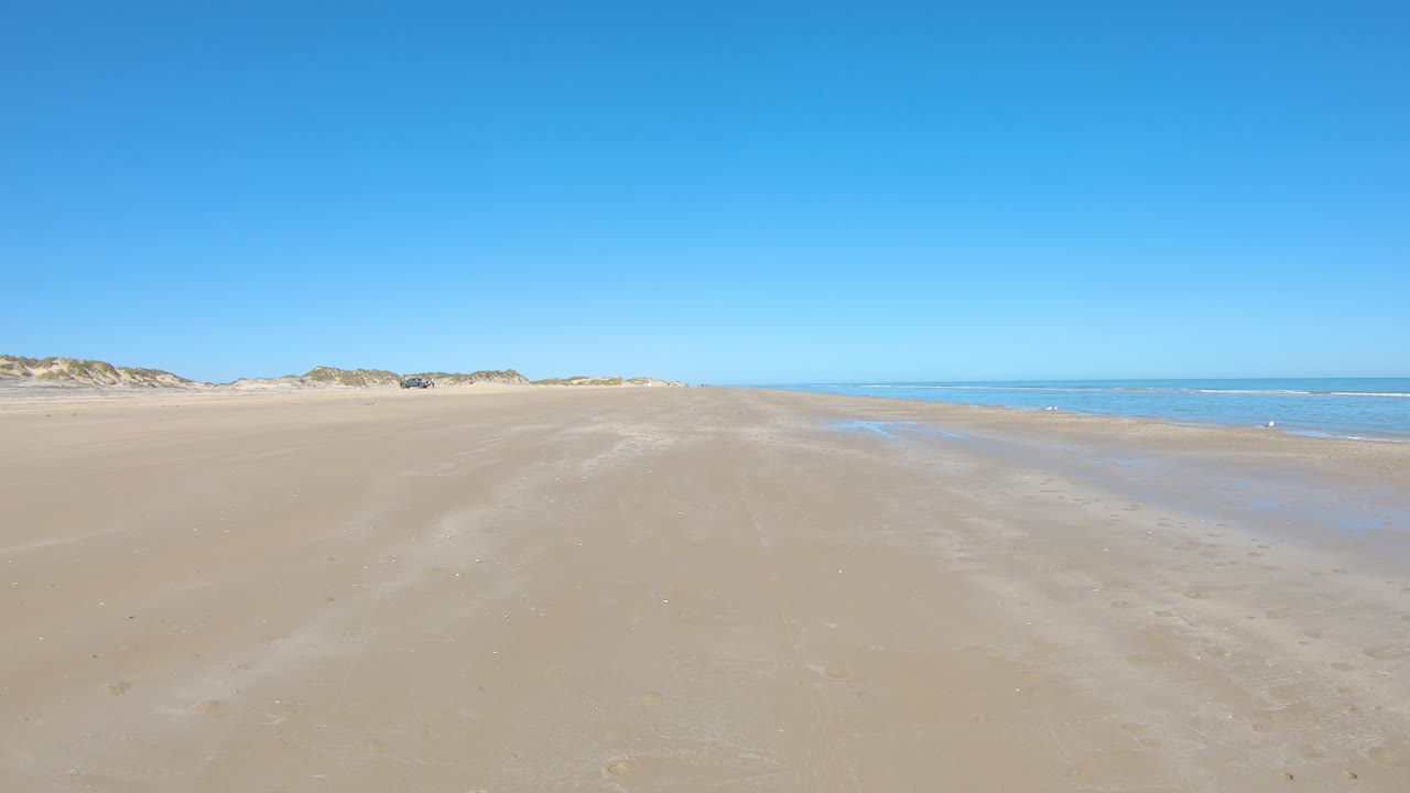 썰물 때 고립된 해변에서 운전하는 동안 pov와 멕시코 만의 장벽 섬에 있는 큰 모래 언덕 - 텍사스