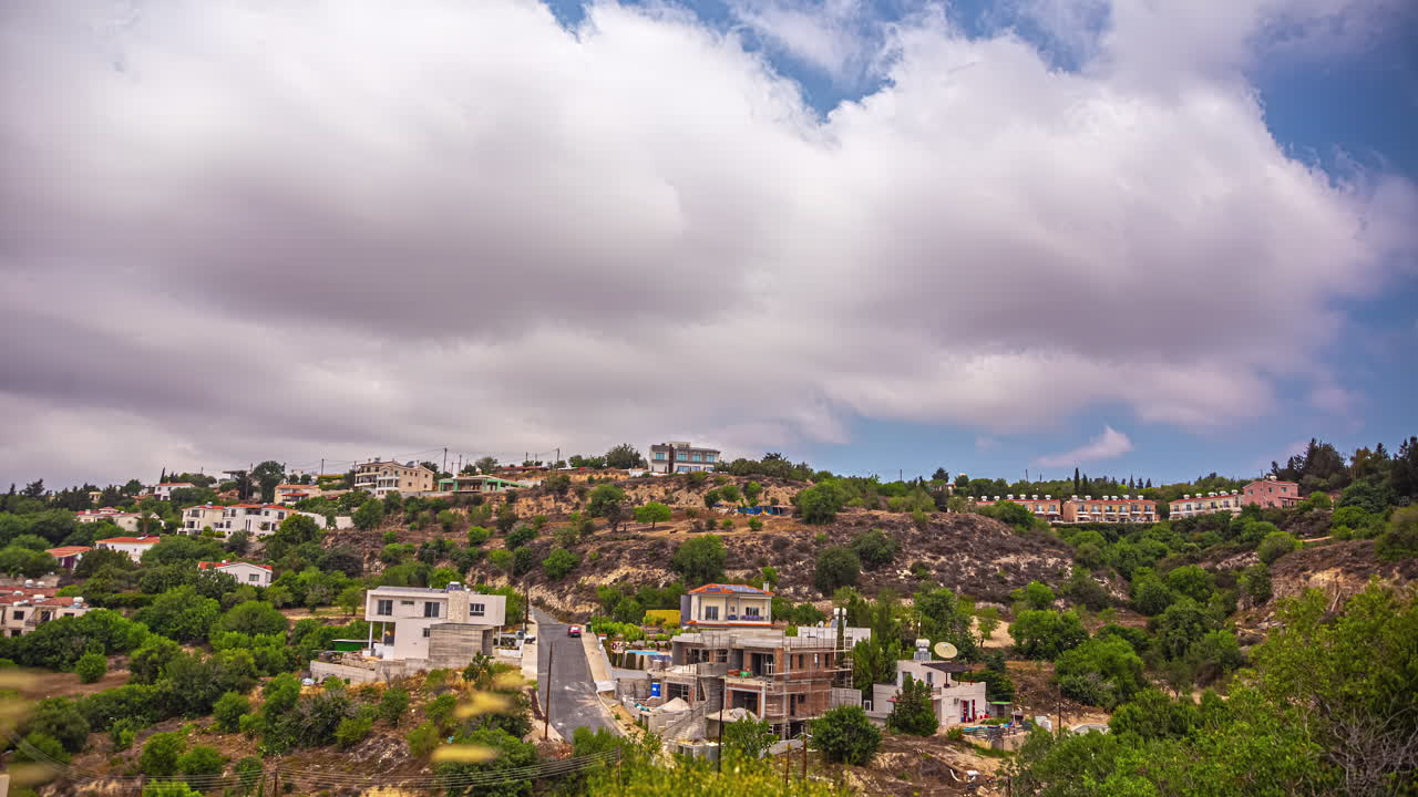 time-lapse de casas de la ciudad a lo largo de una ladera montañosa desde el punto de vista del bosque de picni, chipre en un día nublado