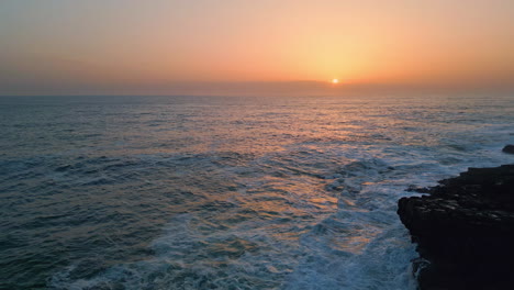 stormy sea sunset horizon landscape slow motion. foamy water crashing dark rocks