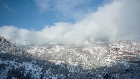 time lapse, clouds above snow capped mountain peaks on sunny winter day