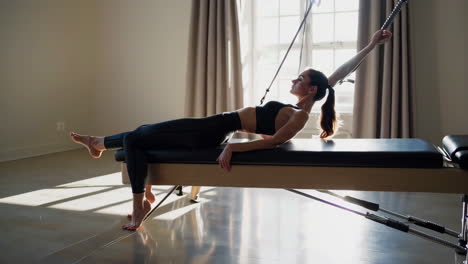 mujer haciendo pilates en un reformador