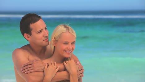 una pareja amorosa abrazada en una playa