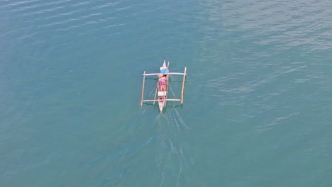 a lone fisherman floats on the calm blue waters of leyte, philippines, under clear skies
