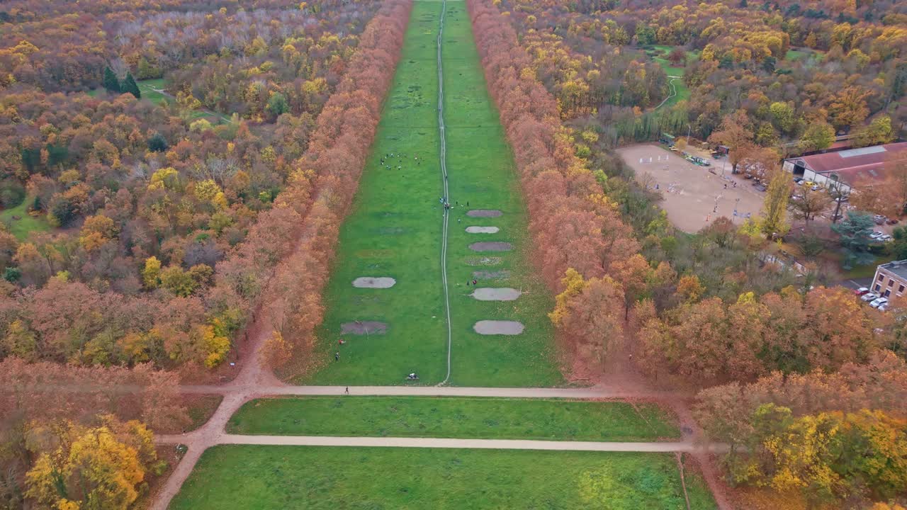 Il drone avanza lungo il corridoio verde nel Bois de Vincennes, con la foresta autunnale su entrambi i lati