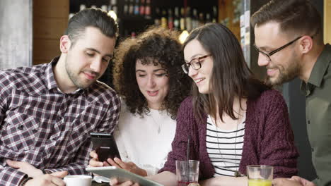 amigos compartiendo un teléfono inteligente riendo