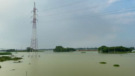 Einspielung-Eines-überfluteten-Feldes-Mit-Großen-Metallmasten-In-Der-Mitte-Bei-Sylhet