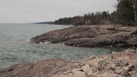 snowflakes drift down over the rocky coastline of lake superior's north shore