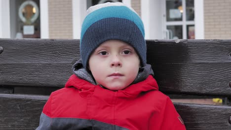 Sad-boy-sitting-alone-on-a-bench-on-a-cold-autumn-day