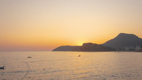 Hermosa-Puesta-De-Sol-En-Una-Playa-Del-Mar-Adriático-En-Sutomore-Montenegro-Con-Montaña-En-El-Fondo