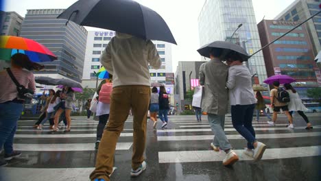 people crossing the street in the rain