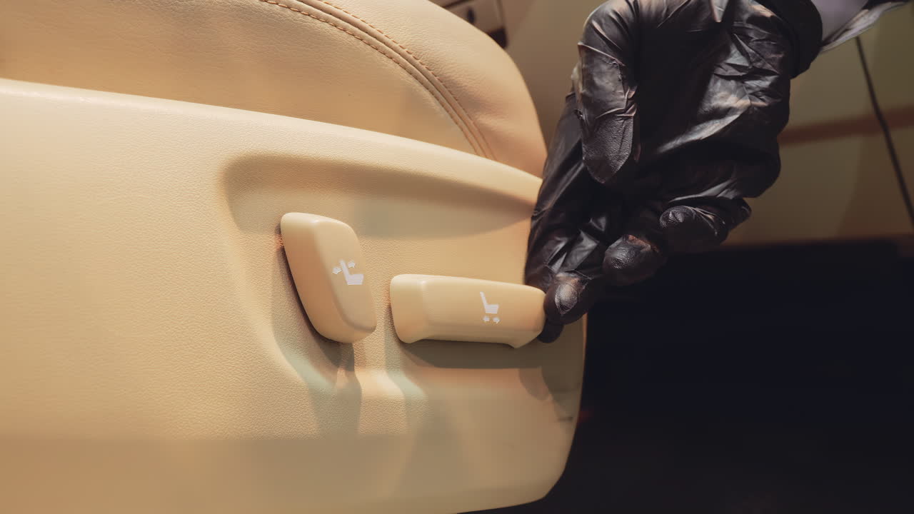 ingeniero probando botones eléctricos de ajuste de asientos con guantes negros para asientos cómodos en automóviles