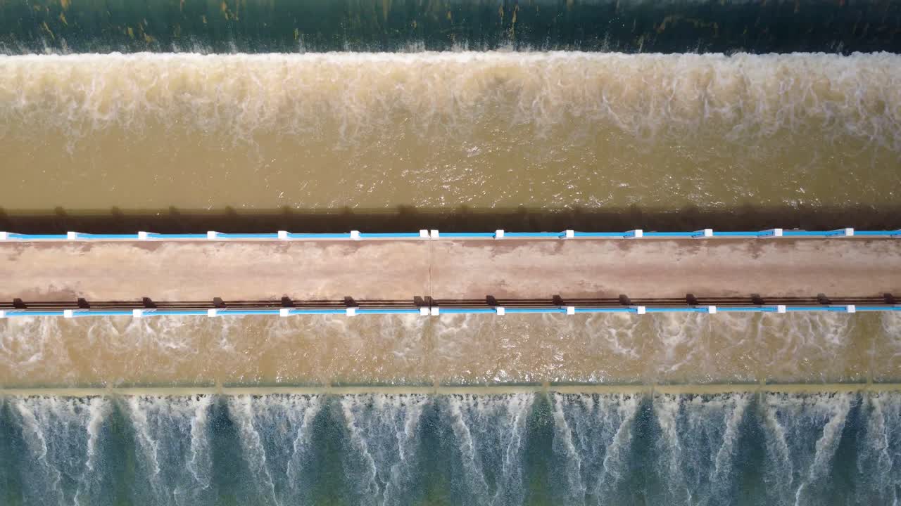 Muddy Water Flowing Through The Spillway Of Dam In Kampong Thom, Cambodia. - aerial shot