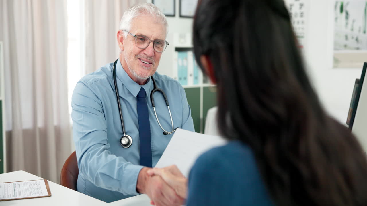 Medico anziano si consulta con un paziente e gli stringe la mano in clinica.