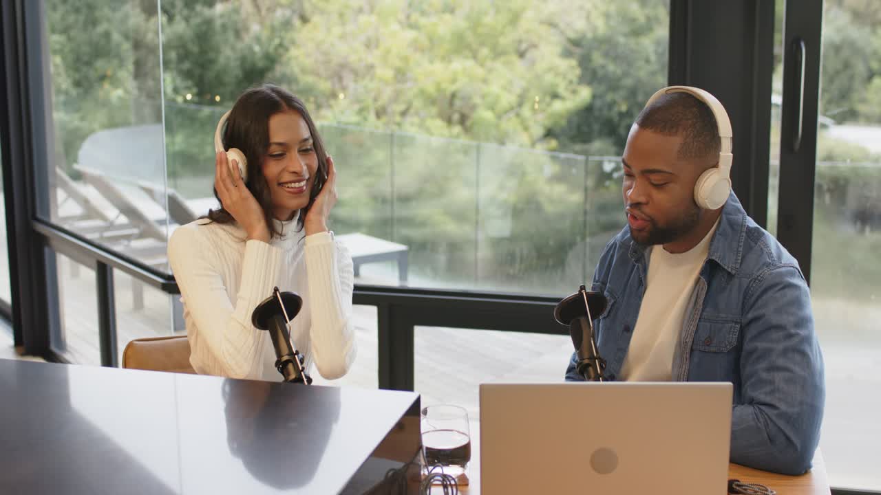 Following audio cue, diverse co-hosts adjusting headsets, testing mics at home studio