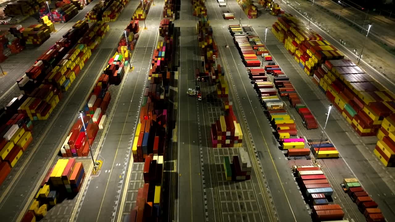 밤에 조명 된 롱 비치 조선소 에 있는 다채로운 국제 화물 운송 컨테이너 를 내려다보는 공중 전망