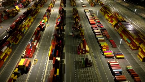 Aerial-view-looking-down-at-multicoloured-international-cargo-shipping-containers-at-Long-beach-shipyard-illuminated-at-night