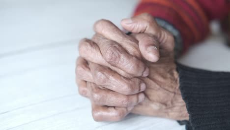 cerca de las mujeres mayores manos en la mesa orando