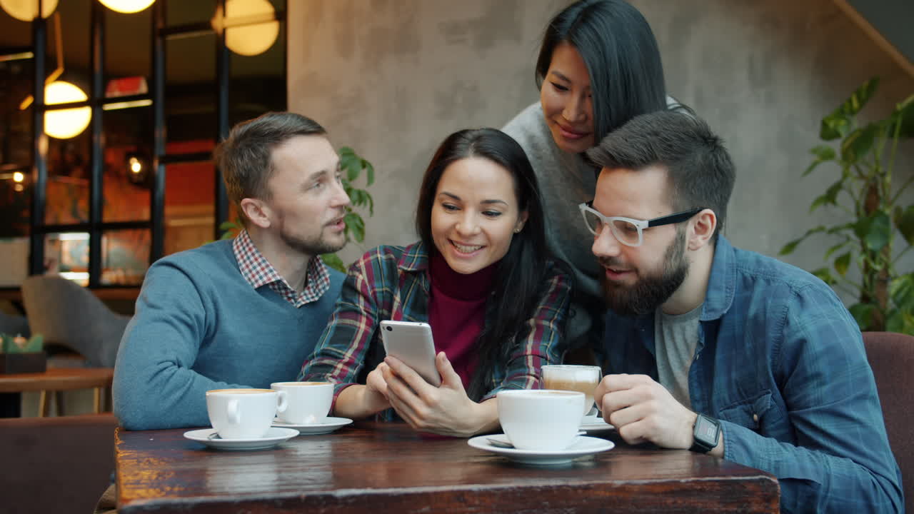 Friends Enjoying Coffee and a Phone in a Cafe