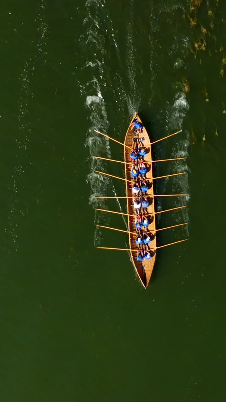 Vertical drone shot above a viking church boat rowing in the finnish archipelago