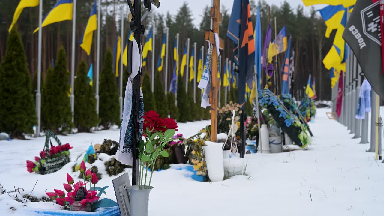 Bouquets of flowers rest on the grave of a Ukrainian soldier at Irpin cemetery, located near the site of early battles from the ongoing Ukraine-Russia war, honoring the fallen.