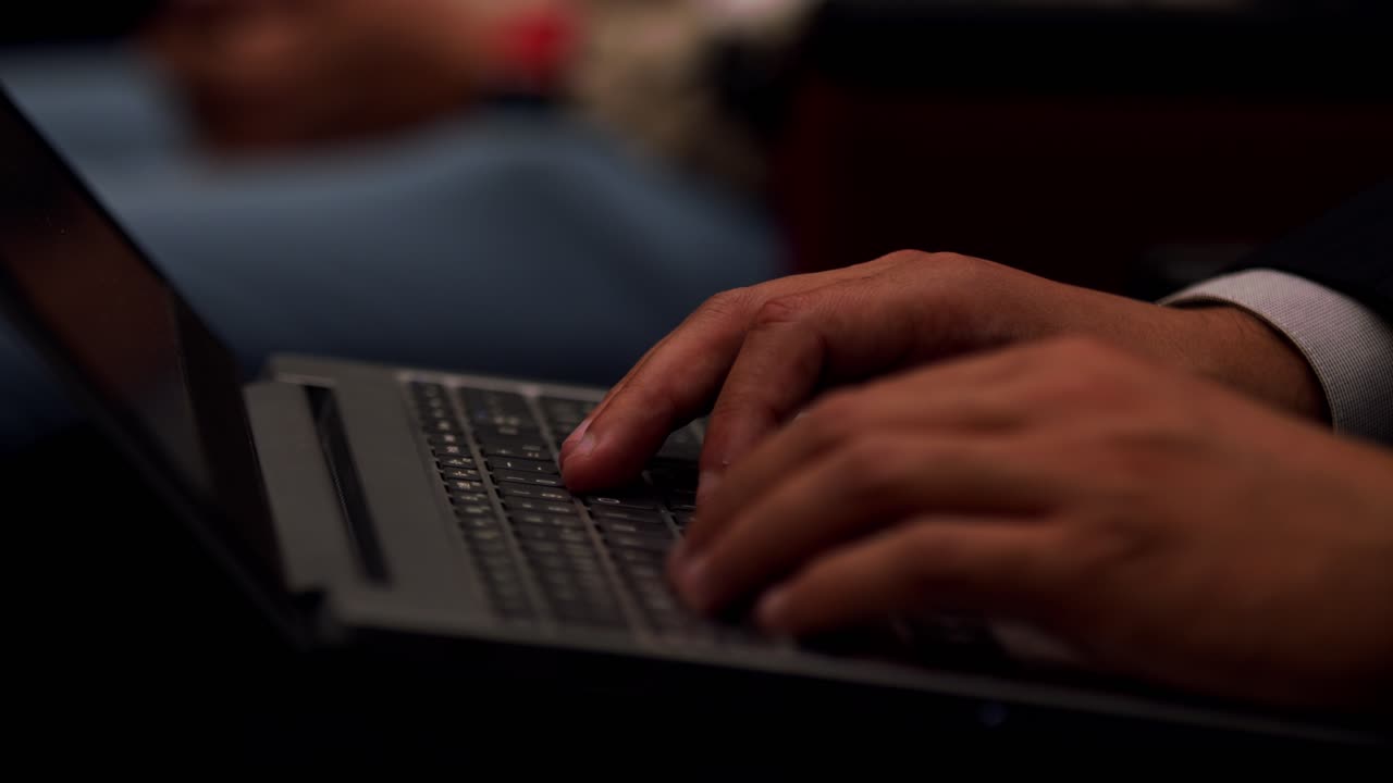 Businessman typing on a laptop, hands in closeup with copy space