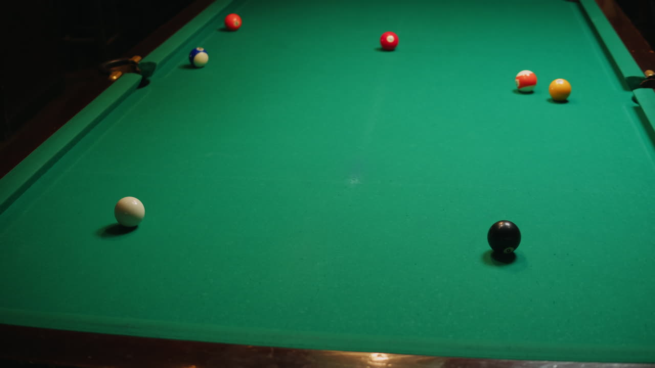 Young men playing American billiard poule close-up. Colorful balls on green billiards table .Billiard balls with numbers on a pool table. Billiards team sport. High quality 4k footage