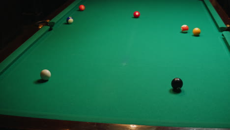 young men playing american billiard poule close-up. colorful balls on green billiards table .billiard balls with numbers on a pool table. billiards team sport. high quality 4k footage