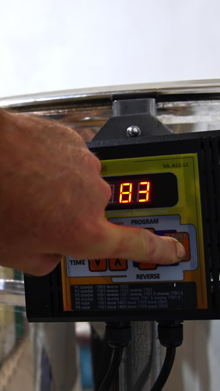 Male hand switching on the button on the centrifuge apparatus. Man presses one more button to increase the speed of work of equipment. Close up. Vertical video
