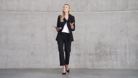 businesswoman in a black suit holding a tablet