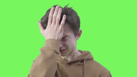primer plano de un niño haciendo un gesto de palma facial. retrato de un adolescente caucásico conmocionado expresando una emoción épica de fracaso. chromakey, fondo de pantalla verde.