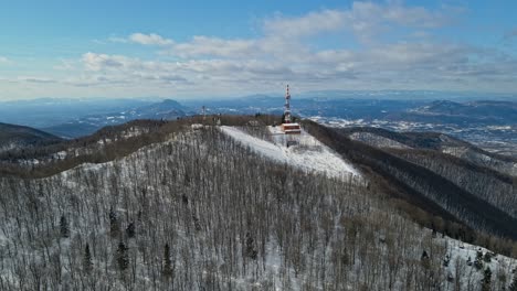 aerial 4k drone footage of a tv and radio communication center on the top of the mountain in the winter time