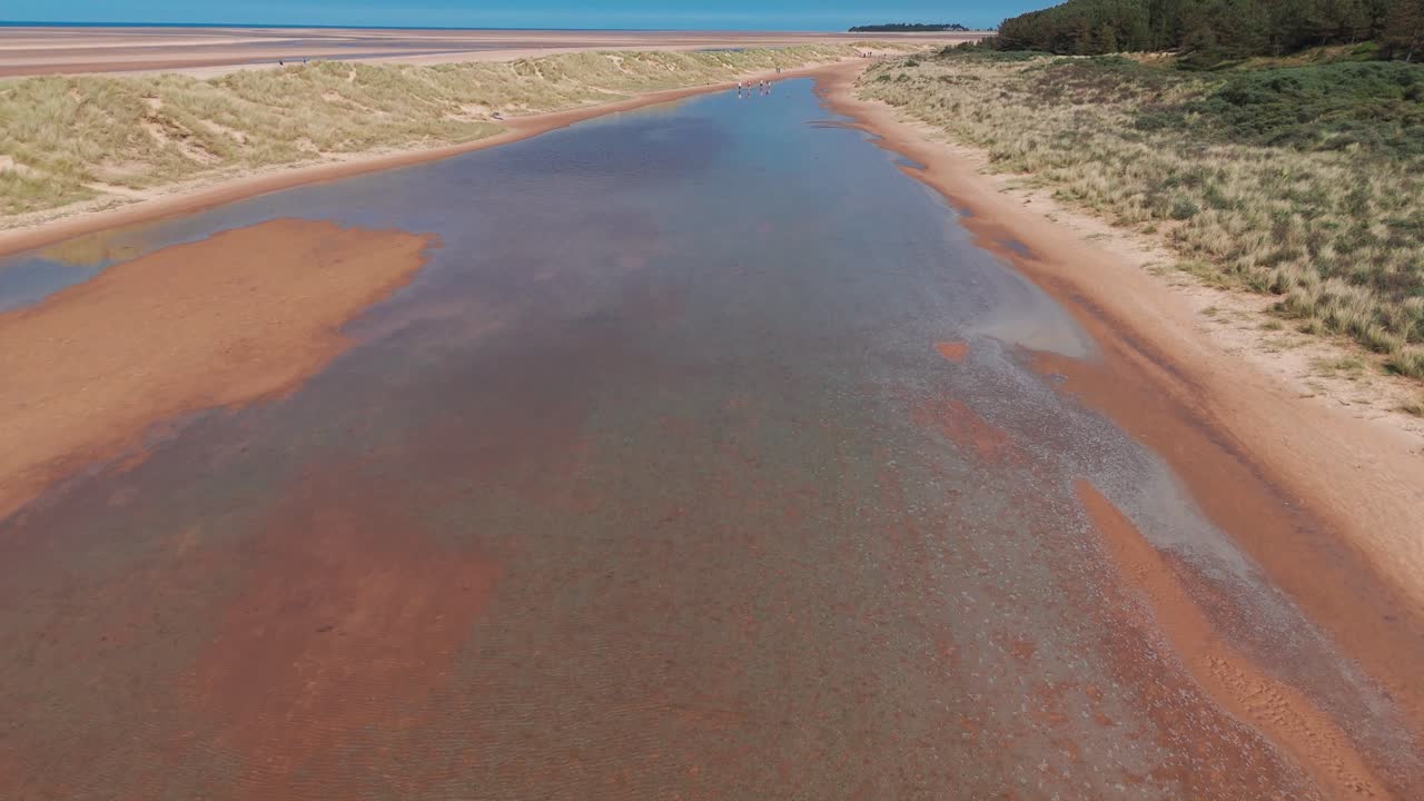The clear waters along holkham bay's coast, showcasing sandy shores, aerial view