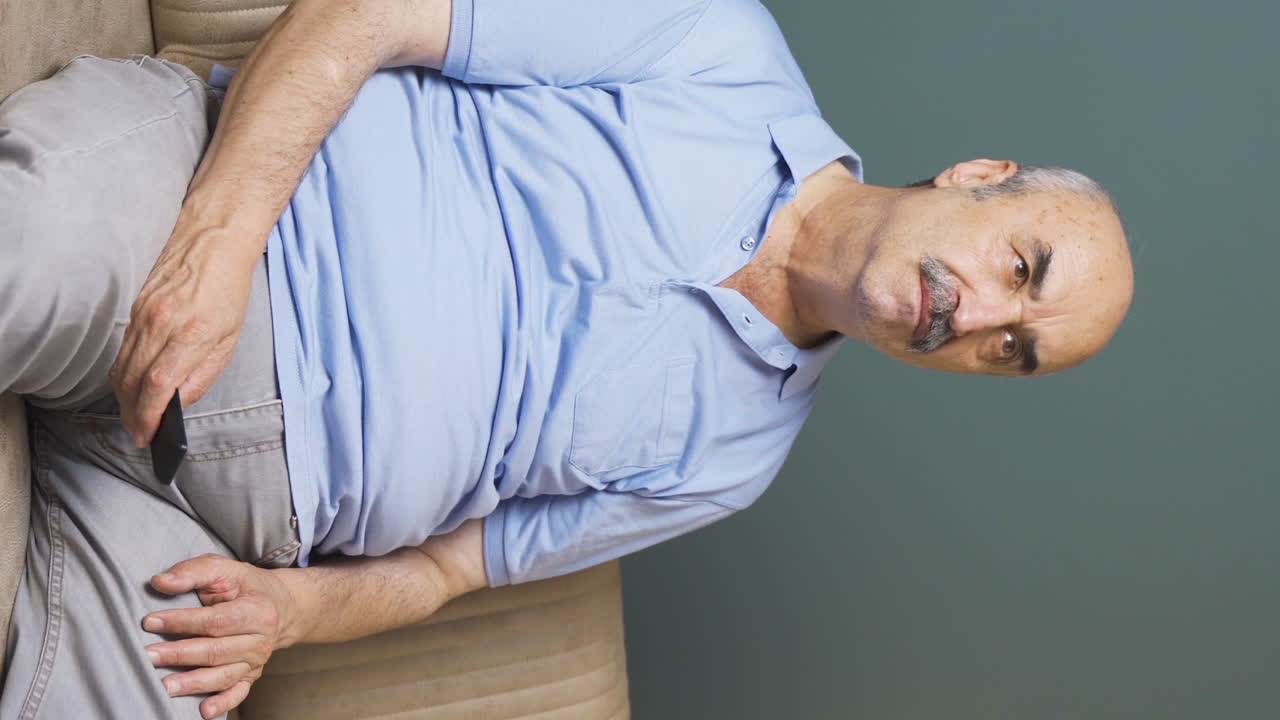 Vertical video of The old man who gets angry at what he sees on TV.