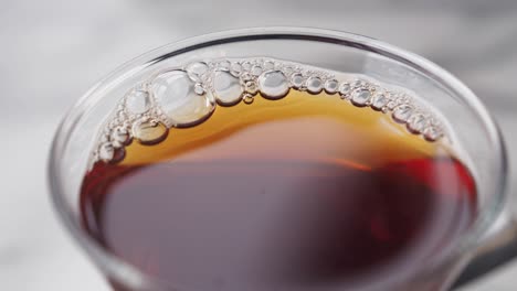 close-up of a glass cup of tea with bubbles