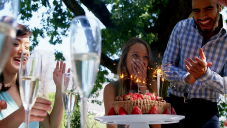 amigos celebrando el cumpleaños de la mujer en un restaurante al aire libre