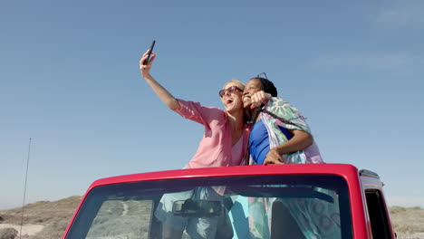una pareja diversa se toma una selfie en un viaje por carretera con espacio de copia en el viaje por carretera, en cámara lenta