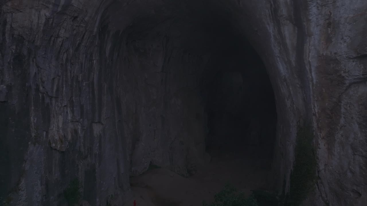 Ripresa aerea della Grotta di Prohodna circondata da una vegetazione lussureggiante, Bulgaria