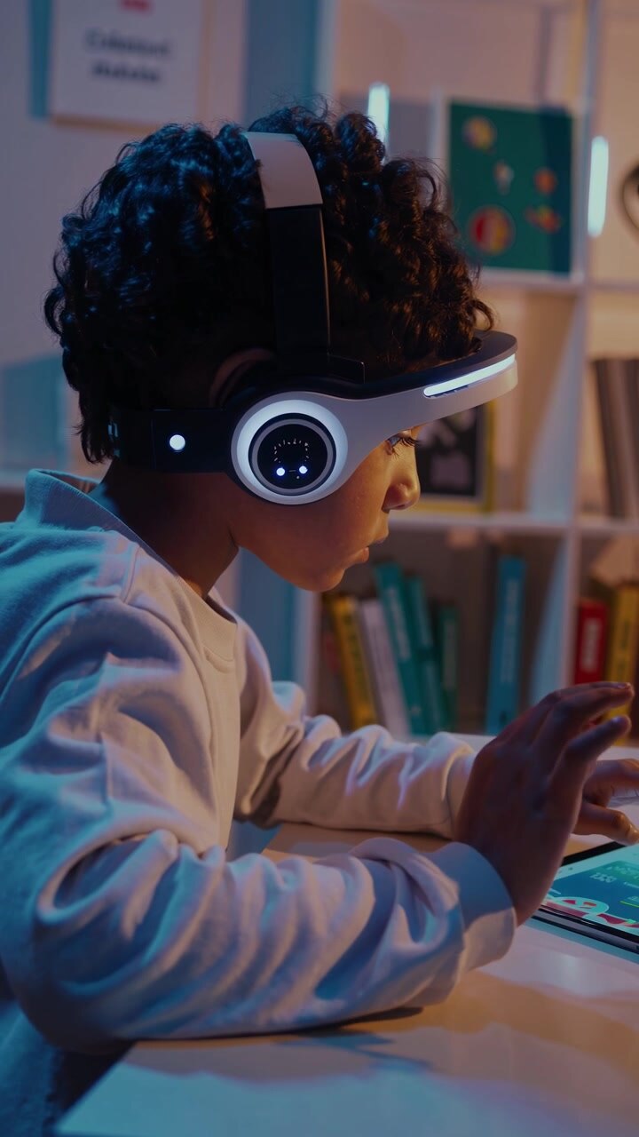 Young Boy Wearing Futuristic VR Headset Using Tablet at Night