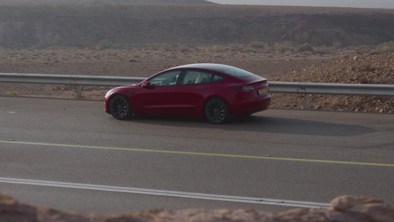 una macchina rossa sul lato della strada nel deserto