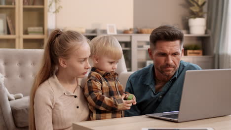 family with toddler using laptop