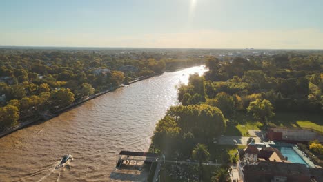 motorboats sailing at lujan river with reflection of sunlight on a sunny day in tigre, buenos aires, argentina