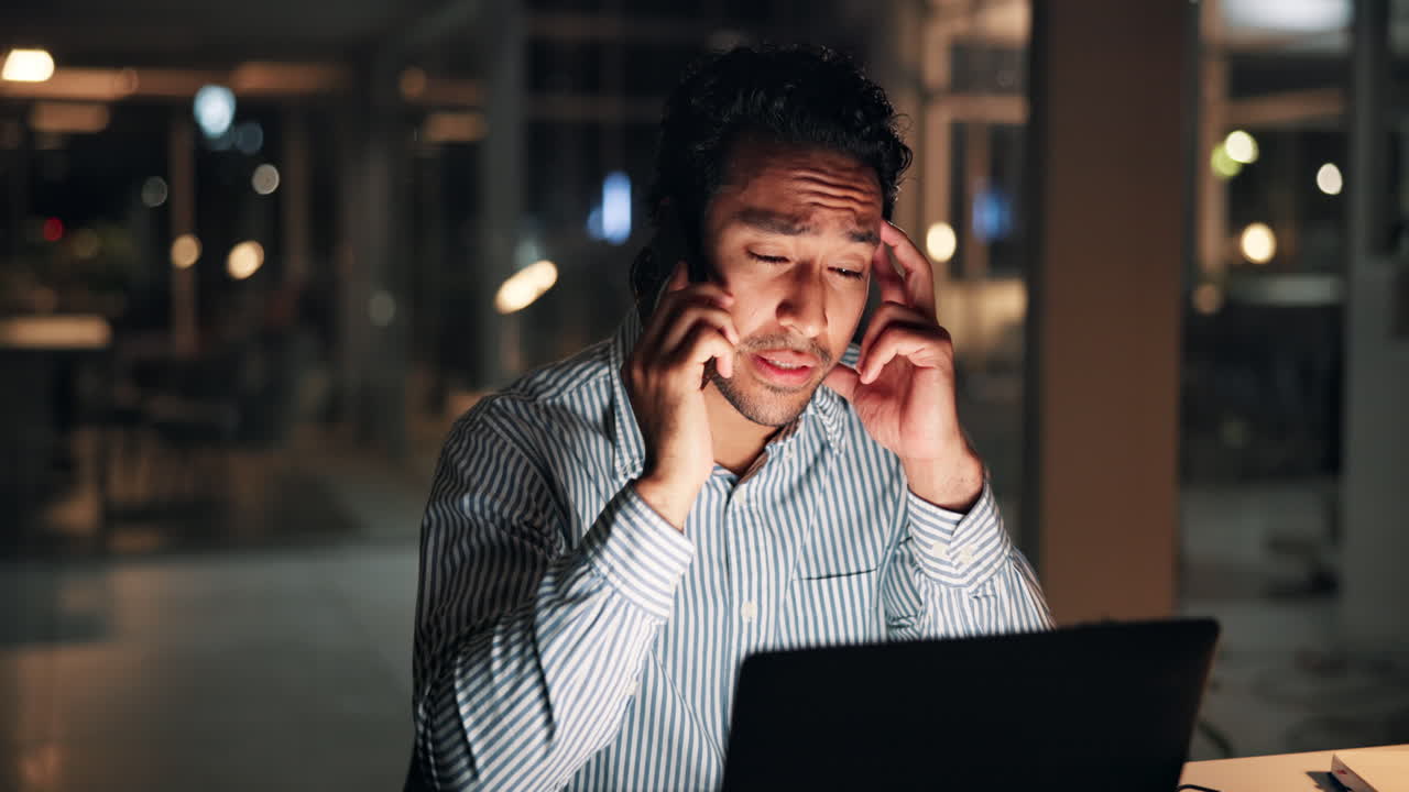 Man Talking on Phone and Working Late in Dark Office