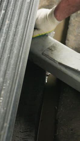 Close-up of an engineer&#039;s hand placing a car lift under a vehicle in an auto repair shop, showcasing detailed mechanical work and safety equipment in use