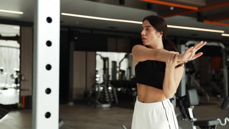 mujer estirándose en un gimnasio