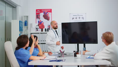 médicos sentados en la sala de juntas del hospital trabajando con imágenes digitales de rayos x