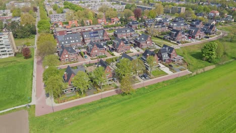 drone flying away from a beautiful modern suburban neighborhood with photovoltaic solar panels on rooftop